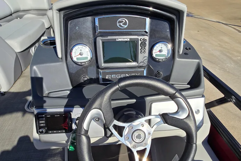 Slide: The Image of 2023 Regency 250 DL3 boat dashboard with steering wheel and navigation controls. - 5