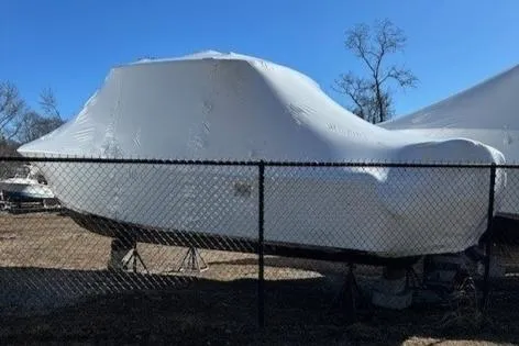Slide: The Image of 2023 Grady-White Freedom 285 boat covered in protective wrap, stored outdoors. - 14