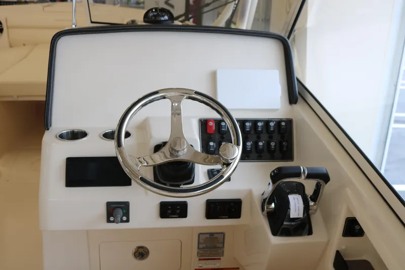 Slide: The Image of 2023 Grady-White Freedom 285 boat dashboard with steering wheel and control panel. - 8