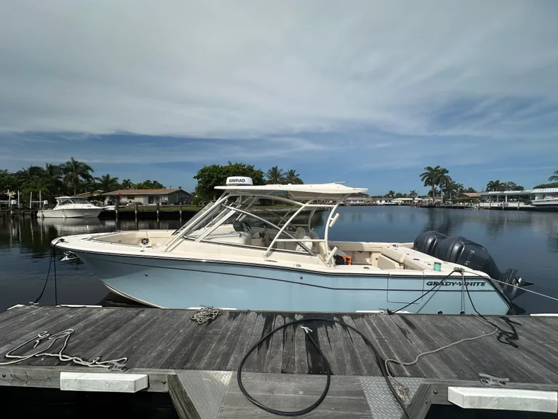 Slide: The Image of 2023 Grady-White Freedom 307 boat docked by a scenic waterfront. - 10