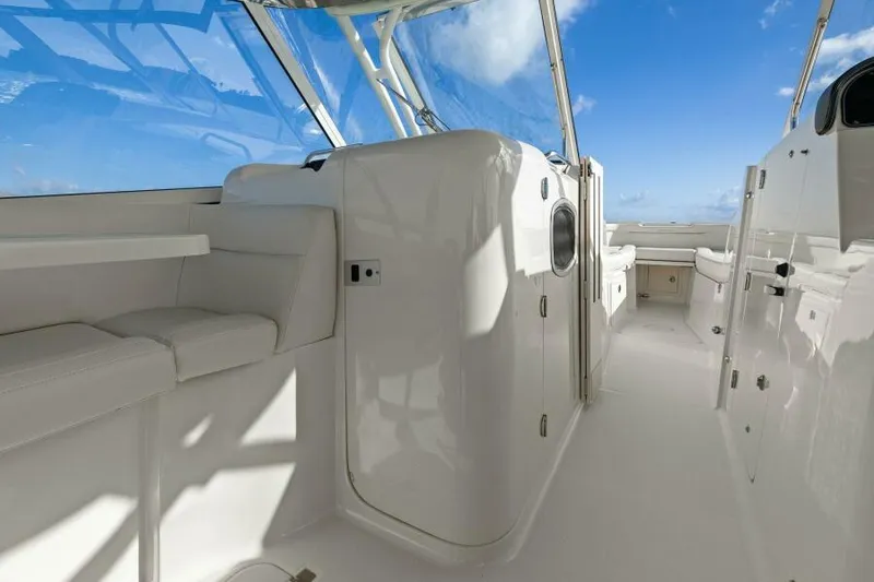 Slide: The Image of 2021 Grady-White 335 Freedom boat interior with white seating and clear blue sky. - 26