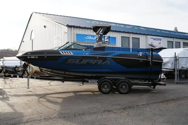 Slide: The Image of 2019 Supra SE 450 boat on trailer outside dealership. - 1