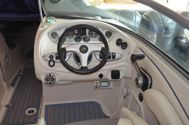 Slide: The Image of 2006 Monterey 268SS boat dashboard with steering wheel and control panel. - 2