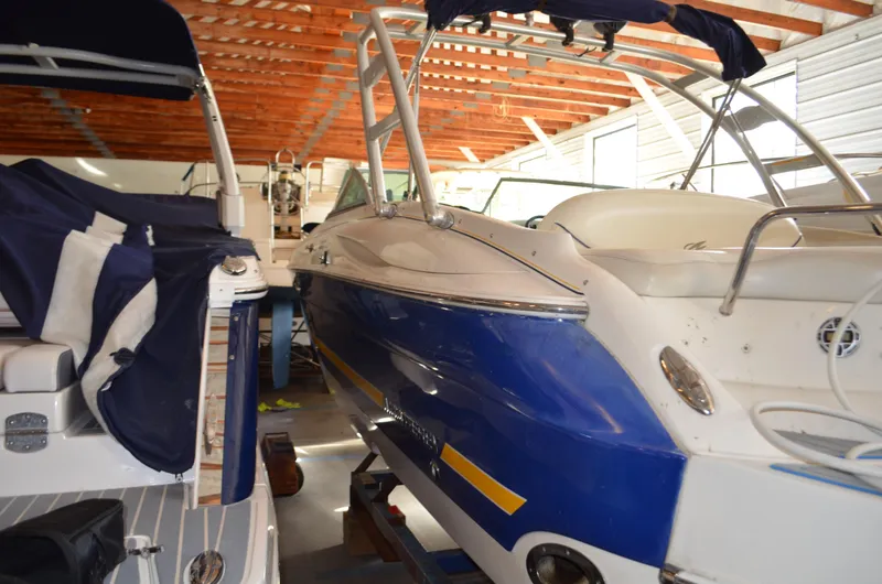 Slide: The Image of 2006 Monterey 268SS boat in storage, featuring blue and white exterior with covered seating. - 5