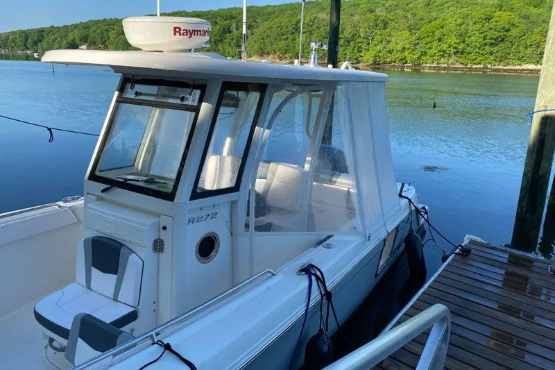 Slide: The Image of 2020 Robalo R272 Center Console boat docked by a serene lake. - 33