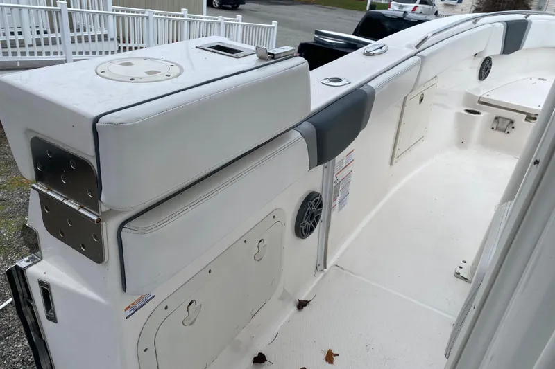 Slide: The Image of 2020 Robalo R272 Center Console boat interior with white seating and storage compartments. - 34