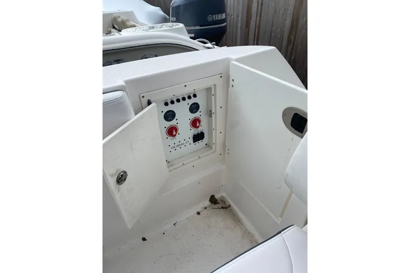 Slide: The Image of 2020 Robalo R272 Center Console boat control panel with open compartment. - 37