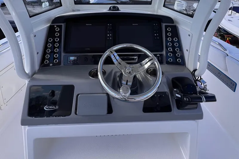 Slide: The Image of 2020 Robalo R272 Center Console boat dashboard with steering wheel and control panels. - 8