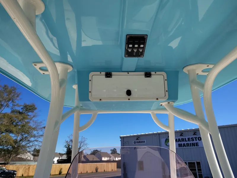 Slide: The Image of 2021 NauticStar 2302 Legacy boat's blue T-top with control panel and storage compartment. - 28