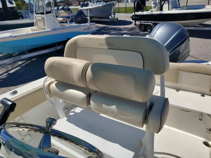 Slide: The Image of 2021 NauticStar 2302 Legacy boat interior with cushioned seating and steering wheel. - 31
