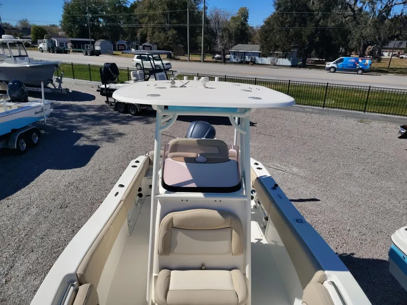 Slide: The Image of 2021 NauticStar 2302 Legacy boat with seating and T-top in a gravel lot. - 4