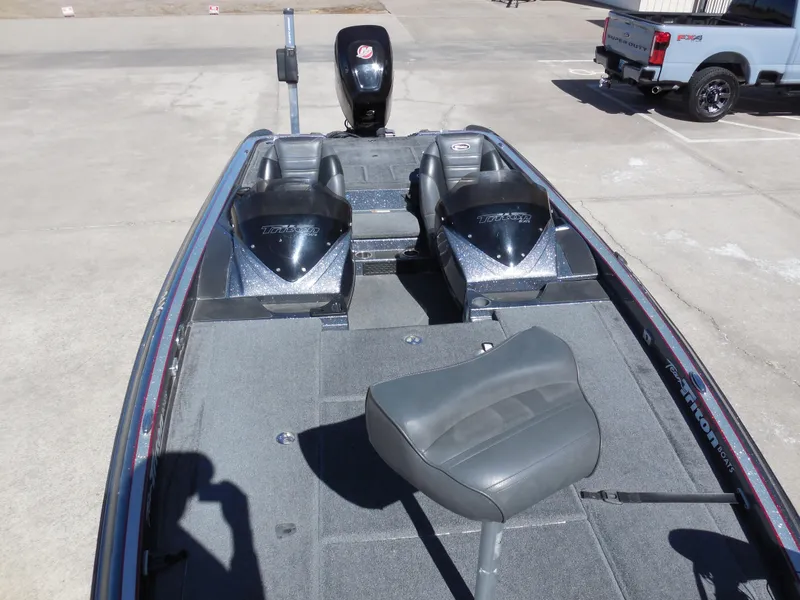 Slide: The Image of 2013 Triton 21XS DC boat with dual consoles and seating, parked on concrete. - 11