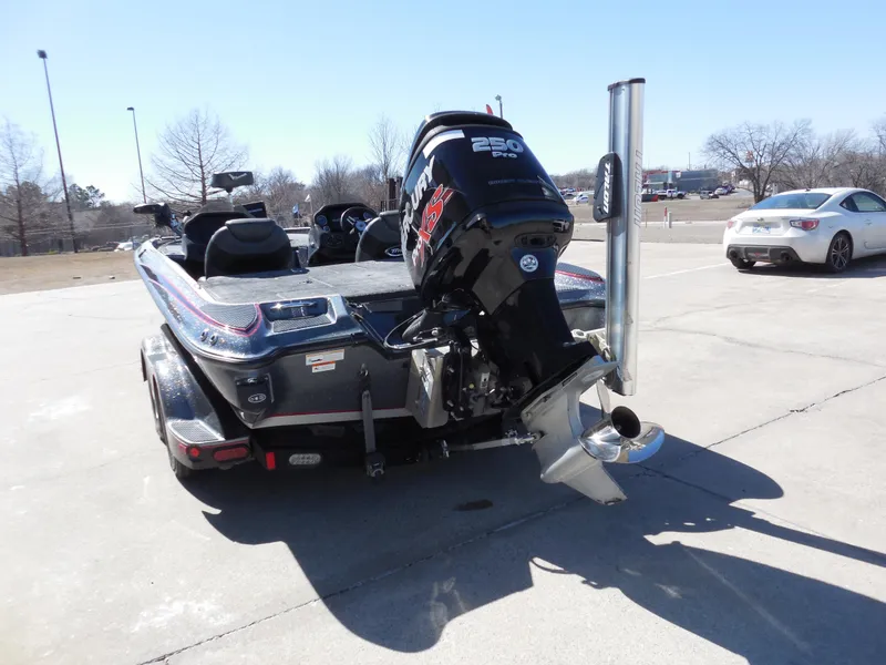 Slide: The Image of 2013 Triton 21XS DC boat with powerful outboard motor in a parking lot. - 4