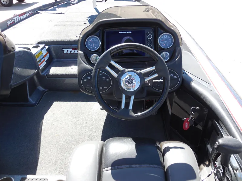 Slide: The Image of 2013 Triton 21XS DC boat dashboard with steering wheel and gauges. - 8