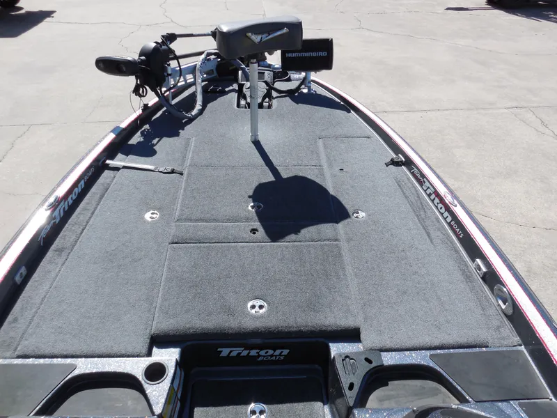 Slide: The Image of 2013 Triton 21XS DC boat deck with fishing equipment and storage compartments. - 9