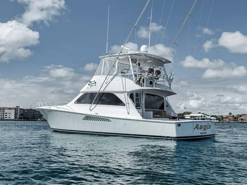 Slide: The Image of 2009 Viking 54 Convertible yacht on calm water under a partly cloudy sky. - 12
