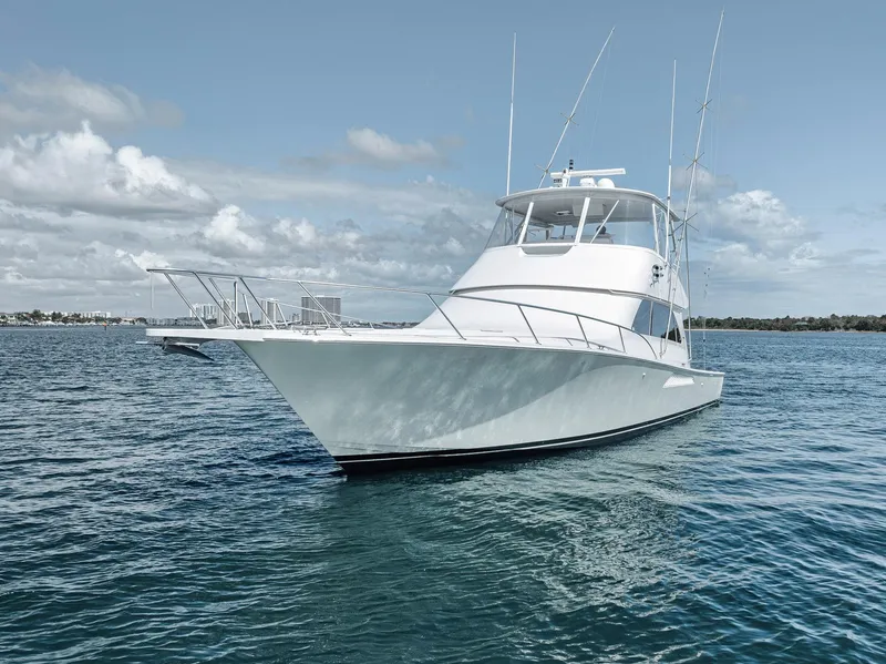 Slide: The Image of 2009 Viking 54 Convertible yacht on open water under a cloudy sky. - 13
