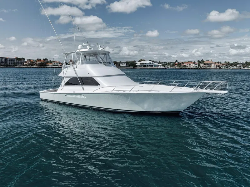 Slide: The Image of 2009 Viking 54 Convertible yacht on calm blue waters under a partly cloudy sky. - 14