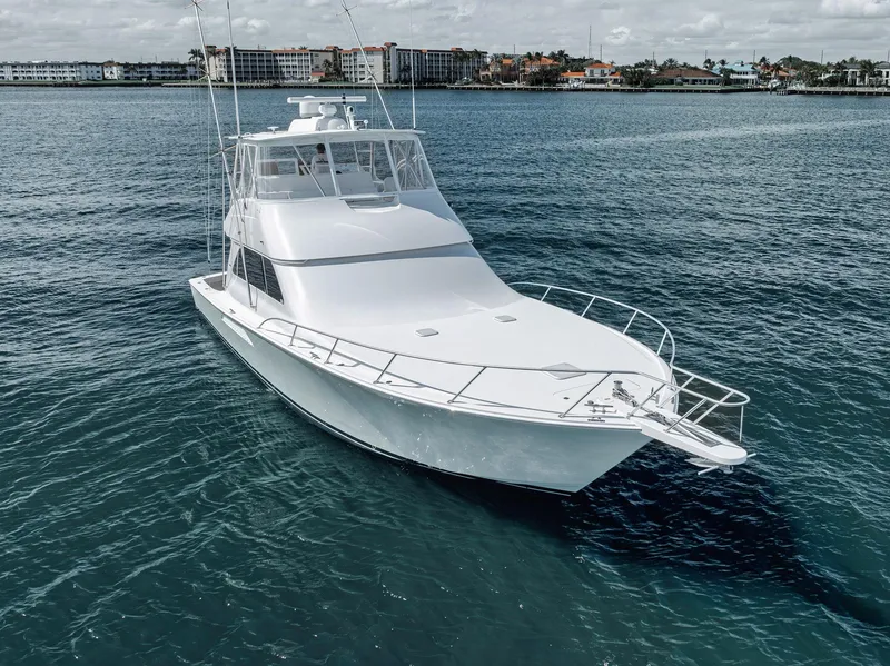 Slide: The Image of 2009 Viking 54 Convertible yacht on calm water, showcasing sleek design and spacious deck. - 17