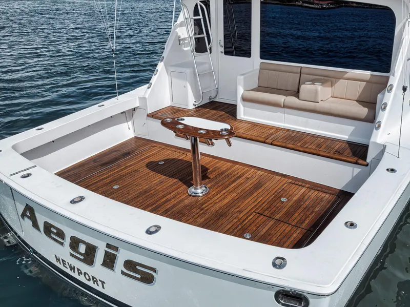 Slide: The Image of 2009 Viking 54 Convertible yacht with teak deck and seating area, docked on water. - 19