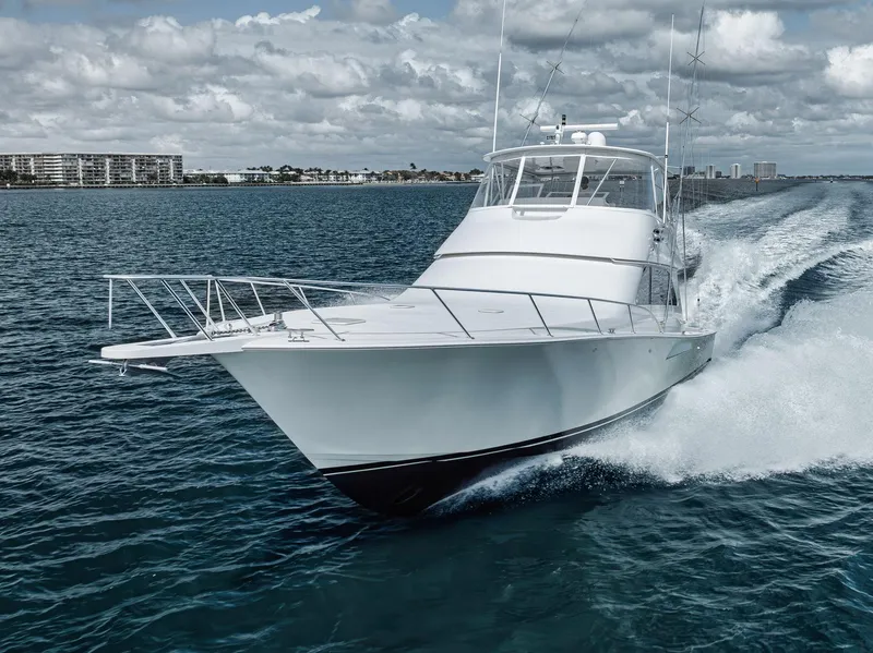 Slide: The Image of 2009 Viking 54 Convertible yacht cruising on open water under cloudy skies. - 3