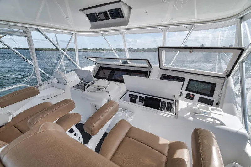 Slide: The Image of 2009 Viking 54 Convertible yacht helm with brown seating and advanced navigation systems. - 47