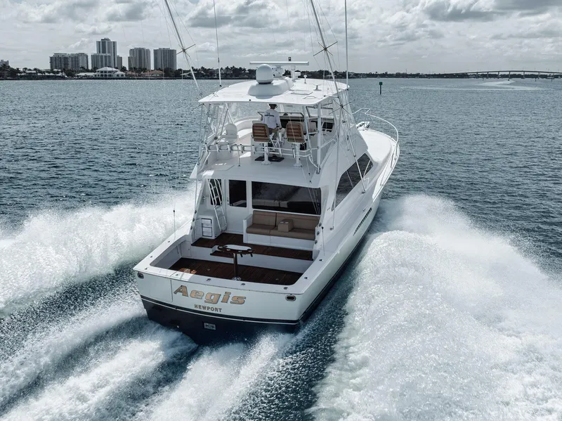 Slide: The Image of 2009 Viking 54 Convertible yacht cruising on open water, city skyline in background. - 6