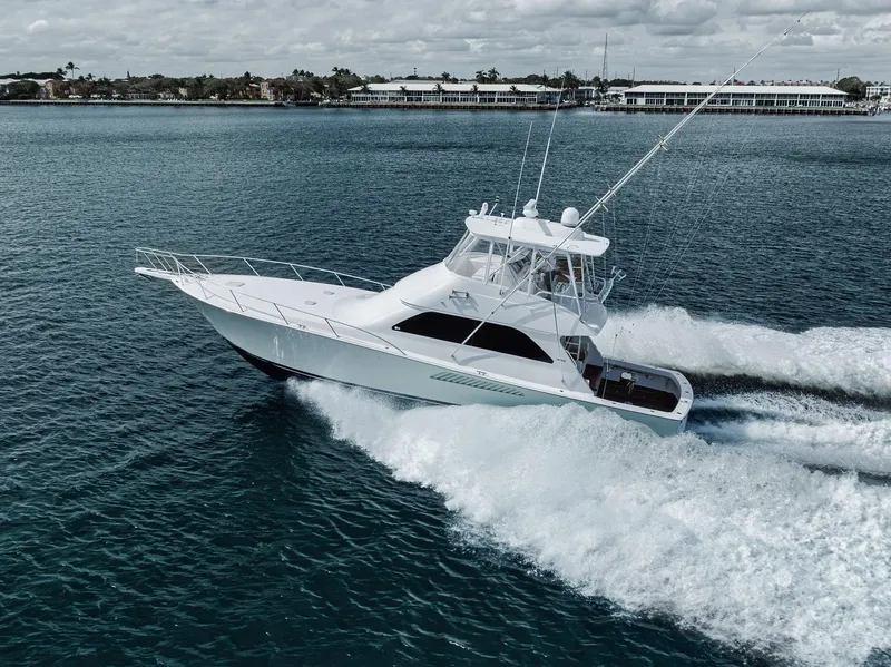 Slide: The Image of 2009 Viking 54 Convertible yacht cruising on open water, creating a dynamic wake. - 9