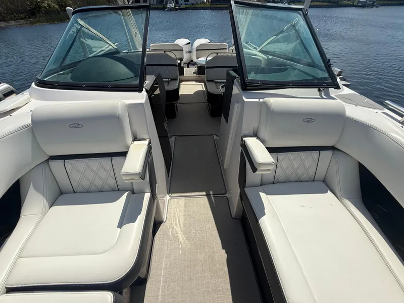 Slide: The Image of 2020 Regal 29 OBX boat interior with white seating and dual windshields on a sunny day. - 18