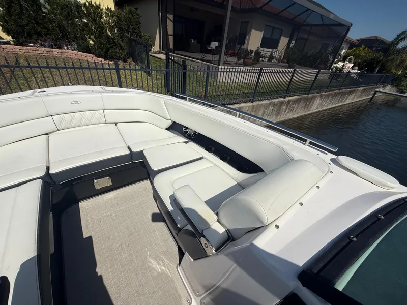 Slide: The Image of 2020 Regal 29 OBX boat with spacious seating, docked by a waterfront home. - 15