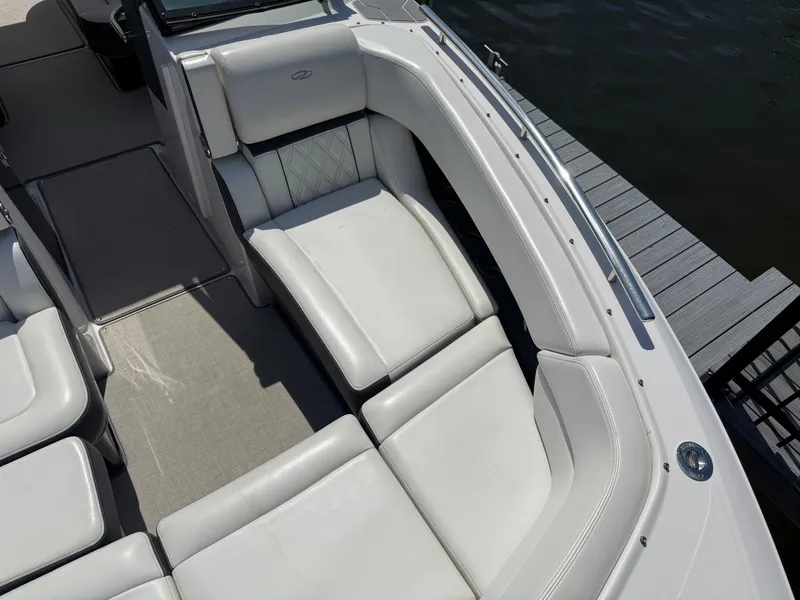 Slide: The Image of 2020 Regal 29 OBX boat interior with white leather seating near dock. - 19