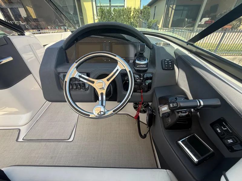 Slide: The Image of 2020 Regal 29 OBX boat cockpit with steering wheel and controls. - 34