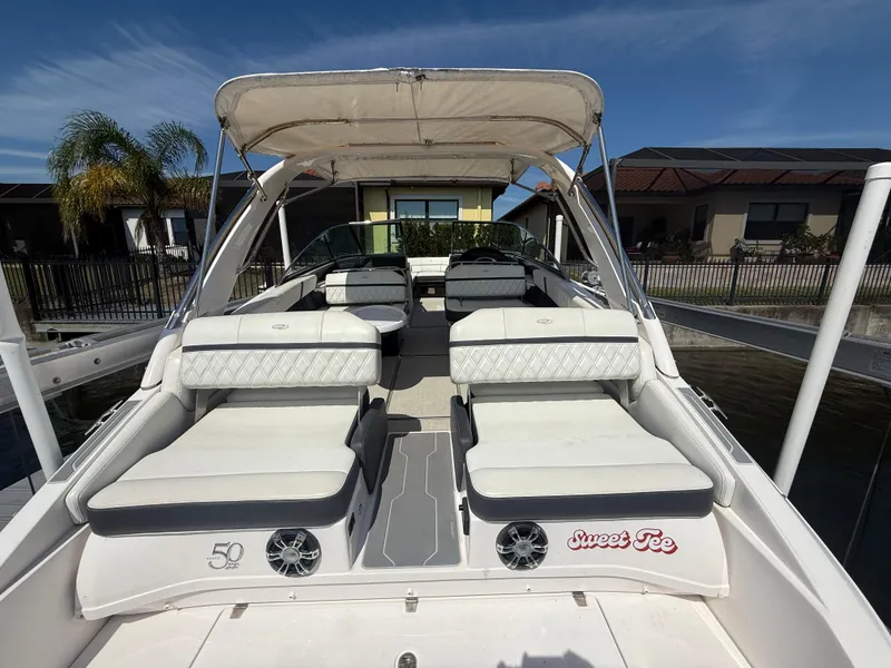 Slide: The Image of 2020 Regal 29 OBX boat with spacious seating and canopy, docked near waterfront homes. - 31