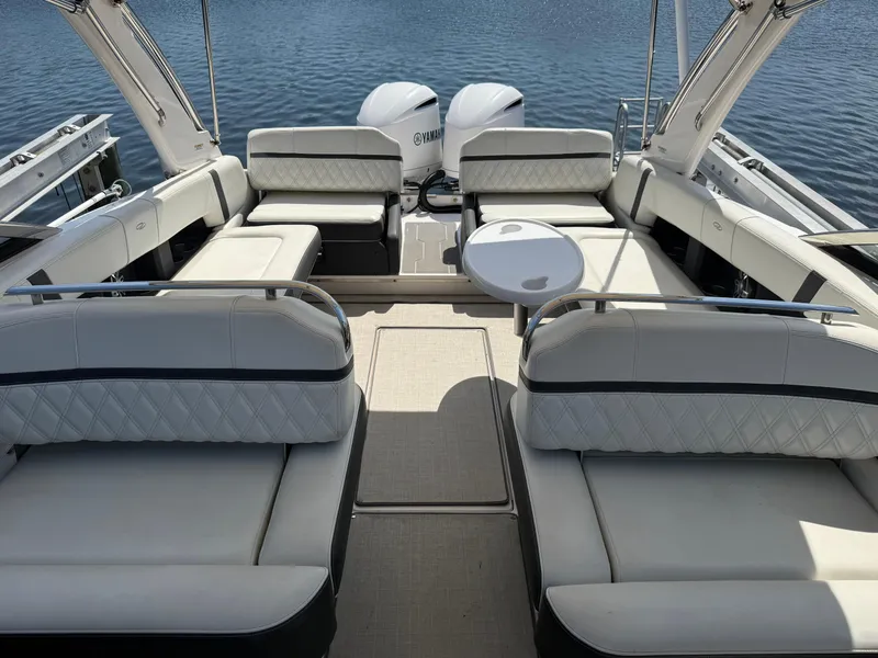 Slide: The Image of 2020 Regal 29 OBX boat interior with luxurious seating and twin engines on a calm lake. - 21