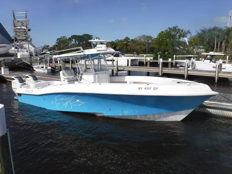 The Image of 2017 Dusky 33 Tournament boat docked, featuring a blue hull and twin engines. - 1