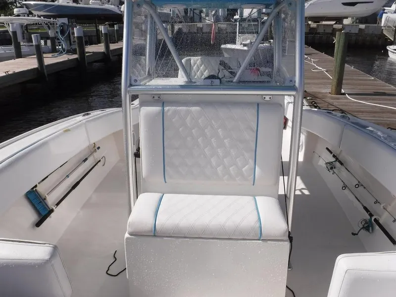 Slide: The Image of 2017 Dusky 33 Tournament boat interior with cushioned seating and fishing rod holders. - 17