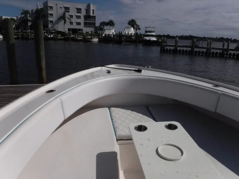 Slide: The Image of Dusky 33 Tournament 2017 boat docked by waterfront buildings and palm trees. - 20