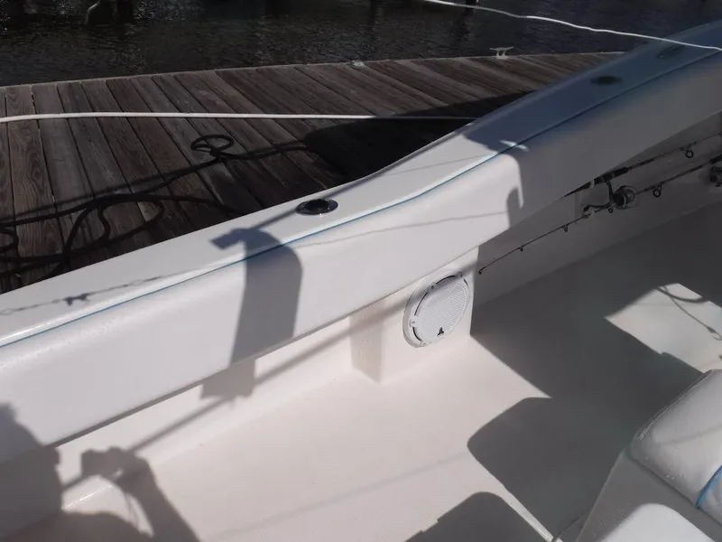 Slide: The Image of 2017 Dusky 33 Tournament boat interior near dock, showing seating and rod holders. - 9