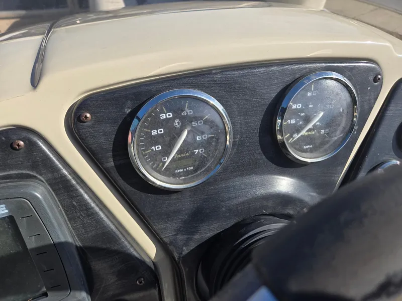 Slide: The Image of Dashboard of a 2014 Sweetwater 2086 boat with speedometer and tachometer gauges. - 12