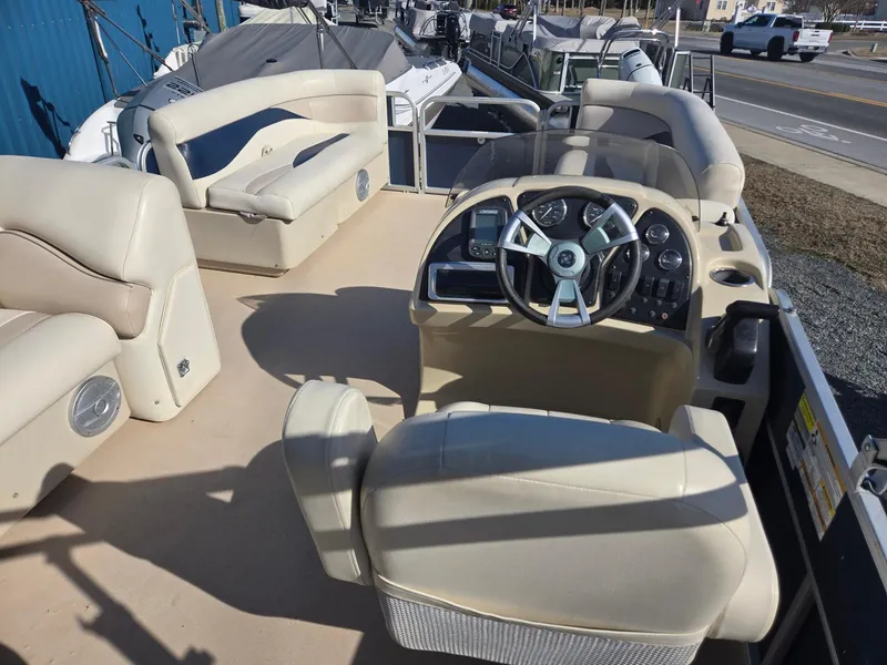 Slide: The Image of 2014 Sweetwater 2086 pontoon boat interior with beige seating and steering console. - 20