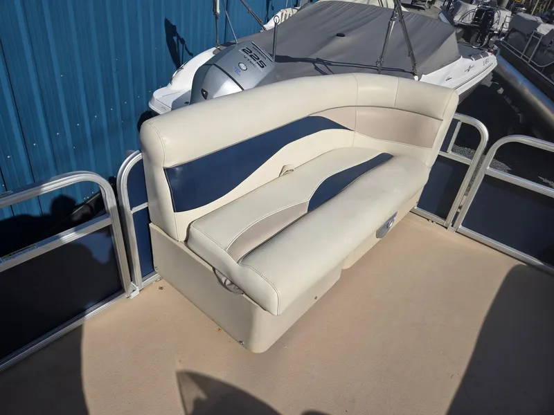 Slide: The Image of 2014 Sweetwater 2086 boat seat with beige and blue upholstery, docked near a blue building. - 23