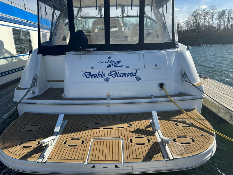 Slide: The Image of 2002 Sea Ray 510 Sundancer yacht docked, named "Double Diamond," with wooden deck and clear canopy. - 1