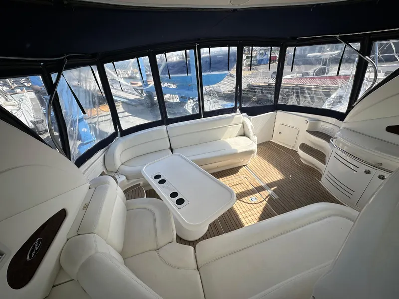 Slide: The Image of Luxurious interior of 2002 Sea Ray 510 Sundancer yacht with white seating and panoramic windows. - 19