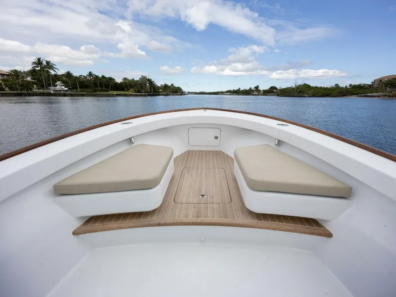 Slide: The Image of 2024 Xcelerator Boatworks 26 with cushioned seating, cruising on a serene waterway. - 10