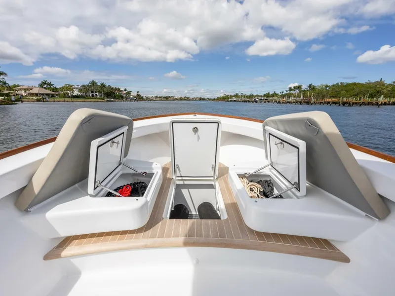 Slide: The Image of 2024 Xcelerator Boatworks 26 with open storage compartments on a sunny day. - 13