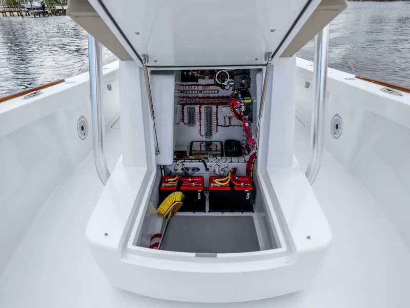 Slide: The Image of 2024 Xcelerator Boatworks 26 electrical compartment with wiring and batteries, dockside view. - 15