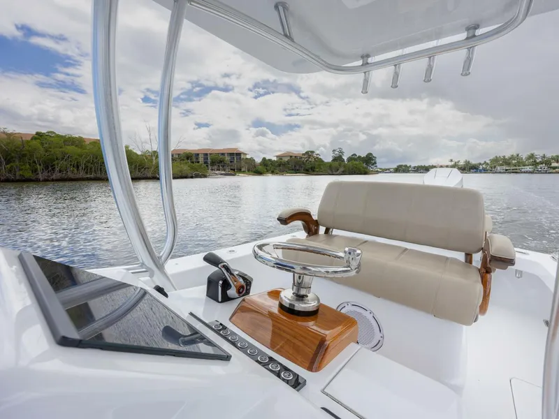 Slide: The Image of 2024 Xcelerator Boatworks 26 helm with modern controls on a scenic waterway. - 18