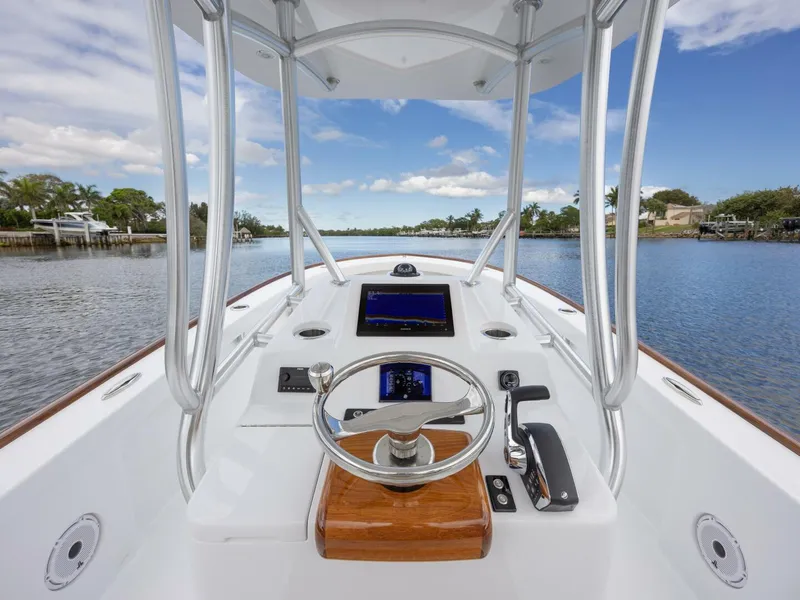 Slide: The Image of 2024 Xcelerator Boatworks 26 helm with modern controls on a scenic waterway. - 20