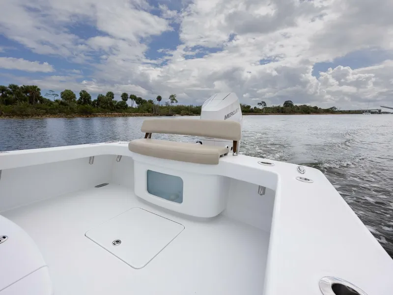 Slide: The Image of 2024 Xcelerator Boatworks 26 on calm water, showcasing spacious deck and seating. - 26