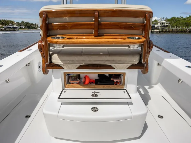 Slide: The Image of 2024 Xcelerator Boatworks 26 with wooden seating and storage, docked by a scenic waterfront. - 28